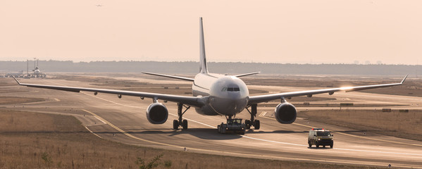 Obraz premium airplane beeing towed on a runway