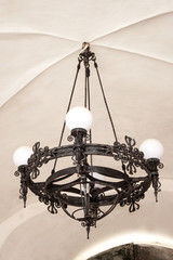 Old electric chandelier lamp on ceiling. 
