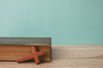 wood cross with bible on table