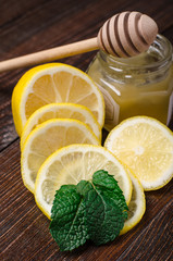 Honeycomb on a wooden table with mint and lemon.