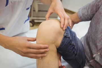 Fototapeta na wymiar Close-up of female doctor examining patients knee