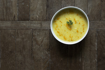 Carrot and turmeric soup on wooden table