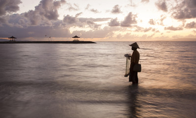 Fototapeta premium silhouette of a fisherman of Bali throwing a net