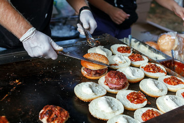 Chef preparing burgers at the barbecue outdoors
