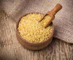 Raw Bulgur (on wooden background)