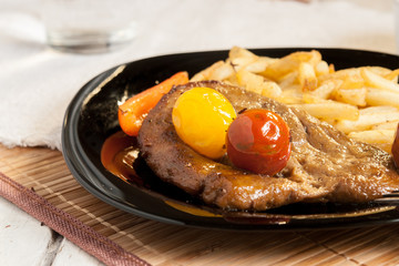 Vegetarian steak from vegan meat seitan, cherry tomatoes and fries