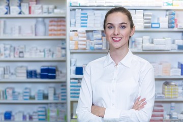 Pharmacist standing with arms crossed in pharmacy