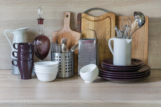 Kitchen still life as background for design. Crockery, tableware and other different stuff on wooden table-top. Image with copy space.