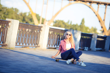 Young girls in skate park with roller skates and skate board