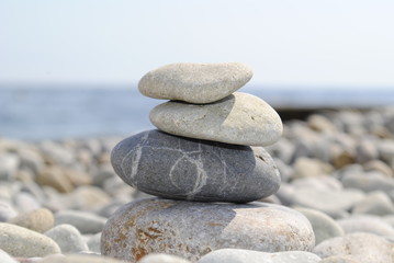 Fototapeta na wymiar Камни/ Камни сложенные друг на друга на фоне глечного пляжа и моря