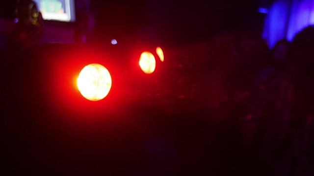 Red turning searchlights in nightclub. Bright color. Spotlights