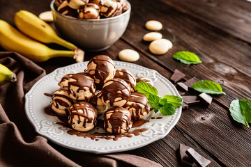 Round sponge biscuits stuffed with banana slices and topped with chocolate