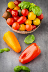 Tomatoes on the gray background. Colorful tomatoes, red tomatoes