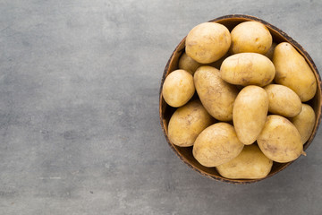 New potato on the bowl, gray background.