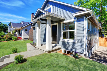 American house exterior with blue siding trim and small concrete floor porch