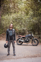 Biker standing by his cruiser motorcycle on a sunny day