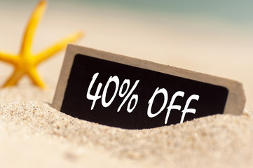 wooden board on sunny sandy beach  with text 40% off