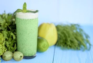 Detox  diet,  healthy food concept. green smoothie in glass, fruits and vegetables on blue wooden desk