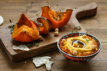 Pumpkin hummus and roasted butternut squash on background