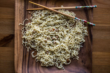 Asian Noodle with Chopsticks in a wooden plate.