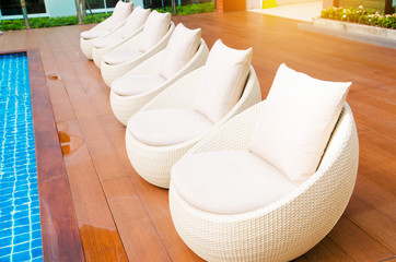 rattan chairs with pillows  beside pool
