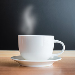 white cup and saucer on wood table