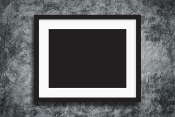 Black photo frame on concreate wall background.