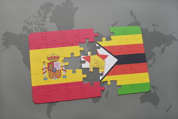 puzzle with the national flag of spain and zimbabwe on a world map background.
