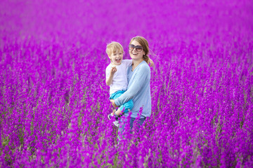 Young woman and her son having fun in purple field