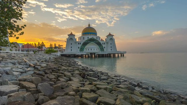 Time lapse 4k Footage of Beautiful Sunrise At Malacca Straits Floating Mosque (Masjid Selat Melaka).  Showing a moving and changing color clouds. Zoom out