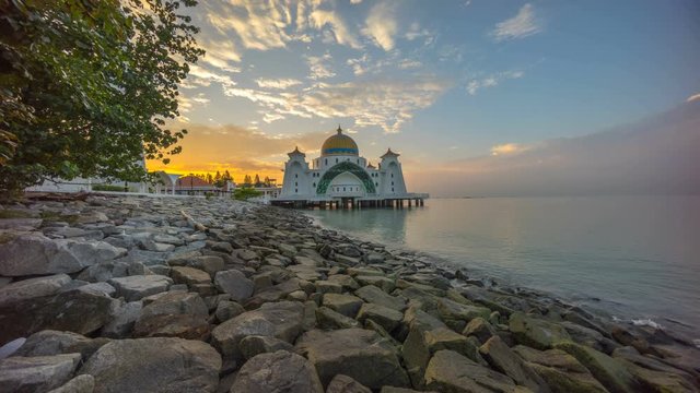 Time lapse 4k Footage of Beautiful Sunrise At Malacca Straits Floating Mosque (Masjid Selat Melaka).  Showing a moving and changing color clouds.