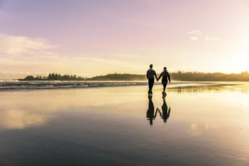 Fotobehang Eiland Sunset at the beach. Tofino Long Beach during the summer. Couple going for a walk as the sun sets. 
