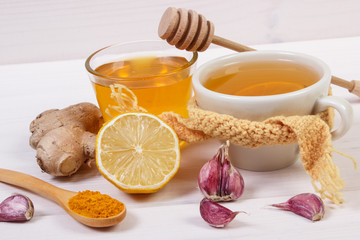 Cup of tea with lemon and ingredients for preparation warming beverage