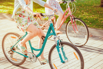 Fototapeta na wymiar The two young girls with bicycles in park