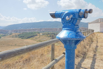 telescope in a viewpoint behind a fence