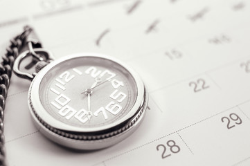 Old pocket watch on calendar page. vintage, black&white