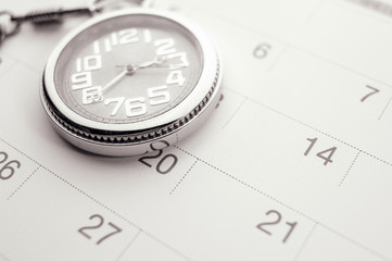 Old pocket watch on calendar page. vintage, black&white