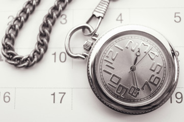 Old pocket watch on calendar page. vintage, black&white