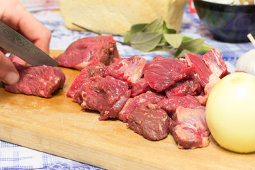 man chef cuts pieces of beef. selective focus