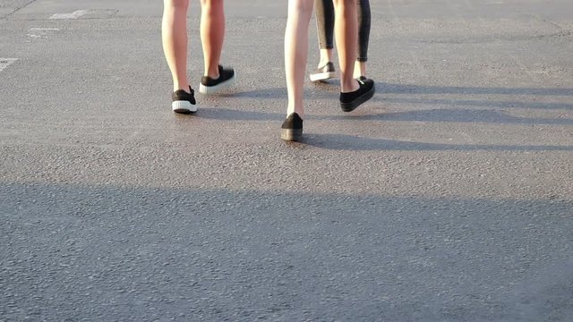 Anonymous pedestrians cross the road in the summer, slow motion