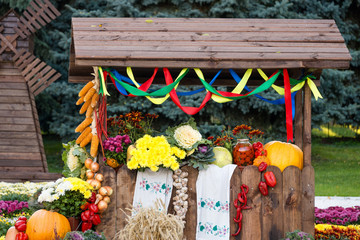 Harvest vegetables on fair trade in a wooden pavilion. Seasonal traditional ukrainian exhibition of farmers achievements. Agricultural products, rural market.