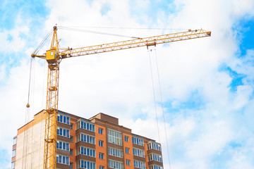 Construction crane and apartment building against.