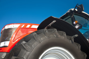 Fototapeta premium Red tractor against the clear blue sky