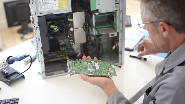 Electrical technician fixing computer hard-drive