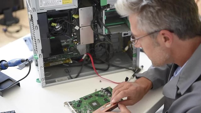 Electrical technician fixing computer hard-drive