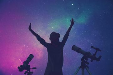 Fototapeta na wymiar Girl enjoying starry skies with telescopes beside her.
