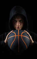 insolent hooded boy holding basketball