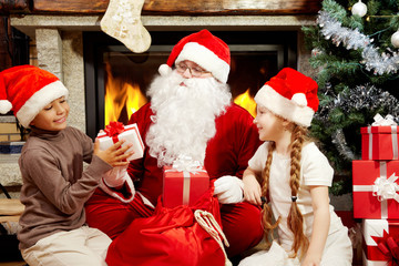 An image of Santa Claus sitting at fireplace and Christmas tree and giving presents to two children
