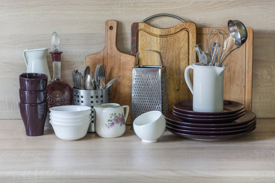 Crockery, tableware, utensils and other different stuff on wooden table-top.Kitchen still life as background for design.  Image with copy space.
