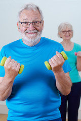 Senior Couple In Fitness Class Using Weights